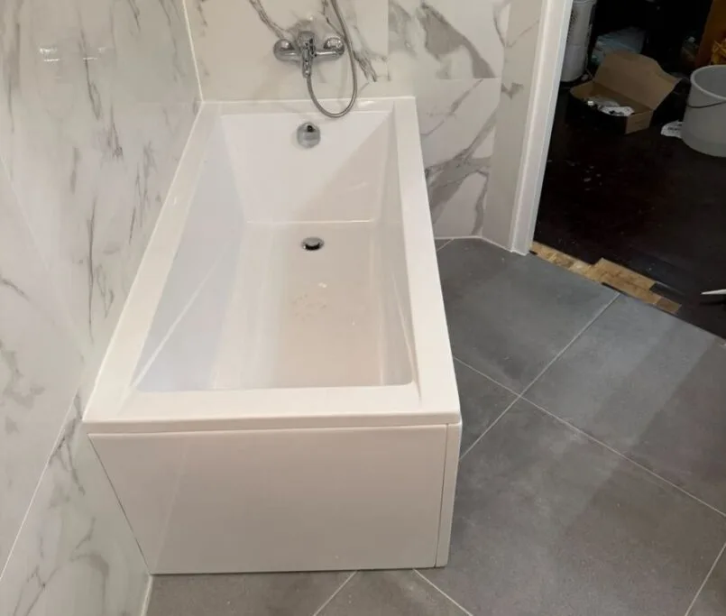 Salle de bain rénovée par Ciprian Rénovation au Vésinet avec faïence effet marbre et baignoire