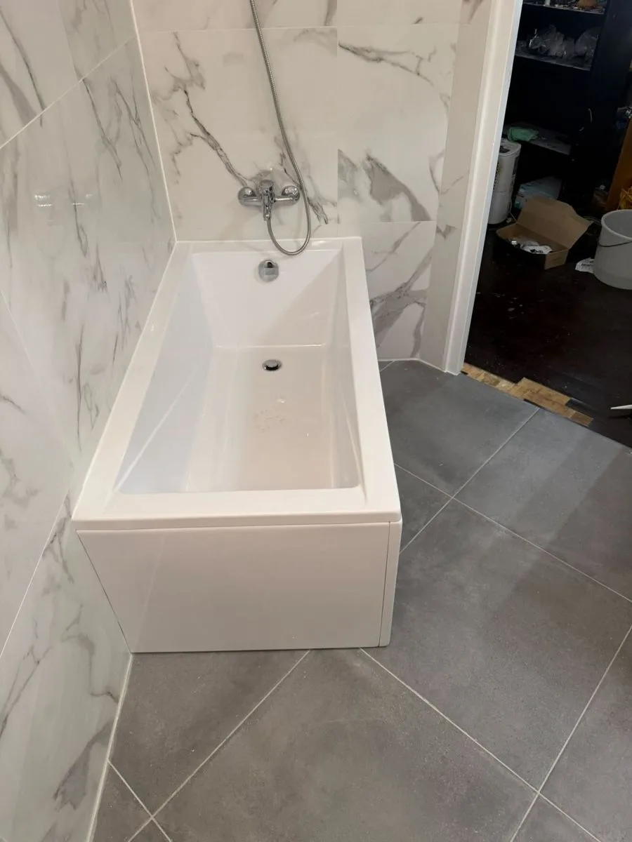 Salle de bain rénovée par Ciprian Rénovation au Vésinet avec faïence effet marbre et baignoire
