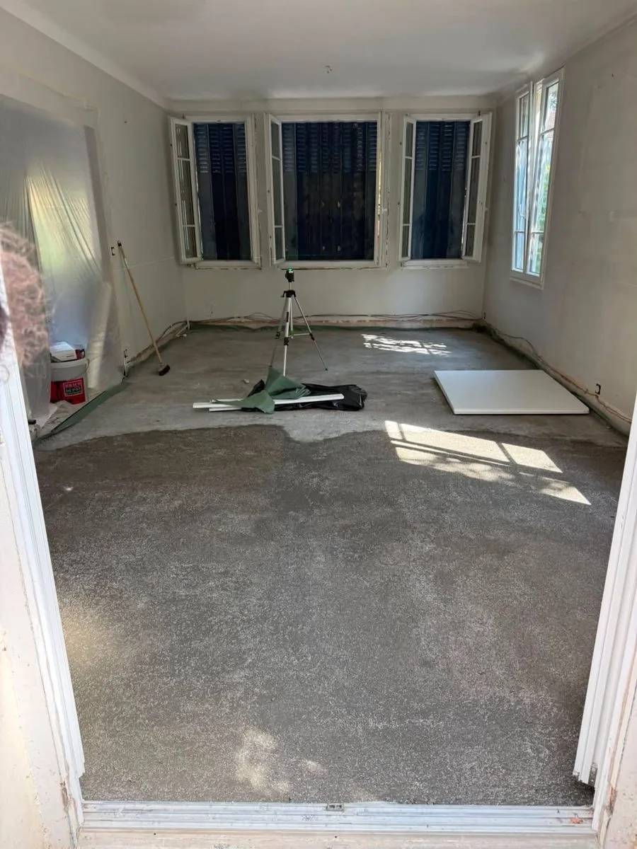 Chape neuve coulée dans une pièce ouverte sur le jardin, rénovation de sol par Ciprian Rénovation à Chatou